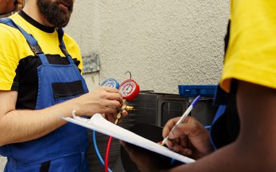 Proficient experts coworkers commissioned to do air conditioner check, refilling freon. Licensed servicemen using barometer set to meticulously measure the pressure in condenser